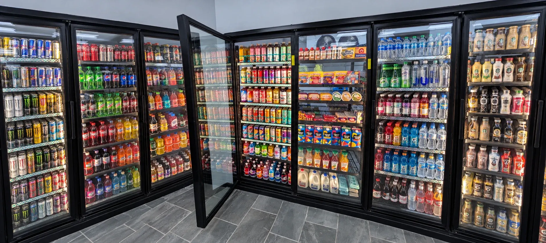 Tall glass cooler display doors with an open door showing stocked shelves