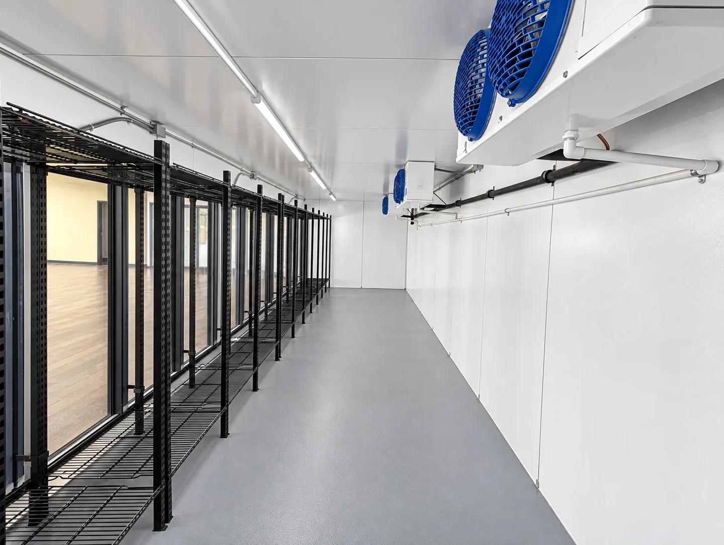 Posts and wire shelving installed along the display doors inside a walk-in cooler